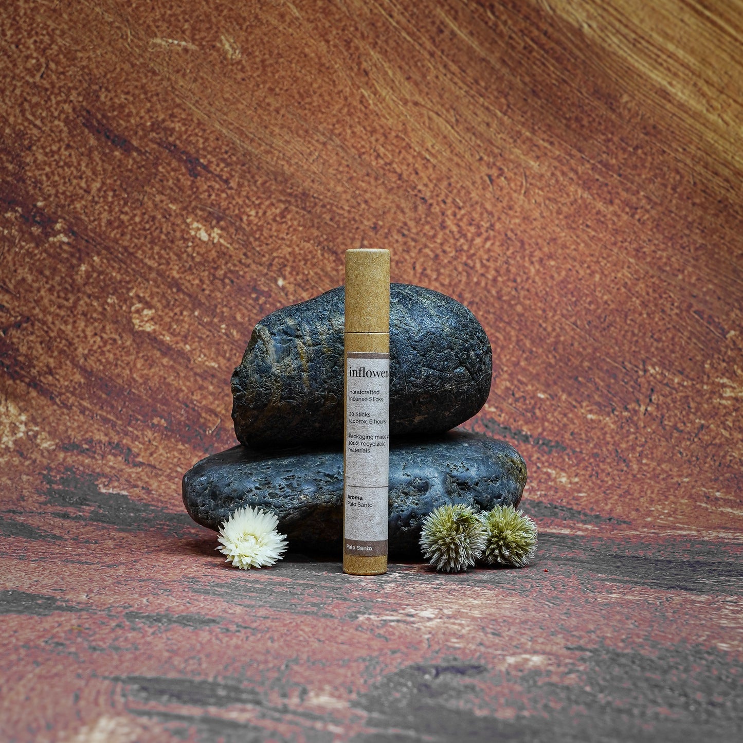 Palo Santo incense tube displayed in front of a Grand Canyon-inspired oil painting backdrop, symbolizing spiritual cleansing and energy renewal with natural serenity and earthy calm.