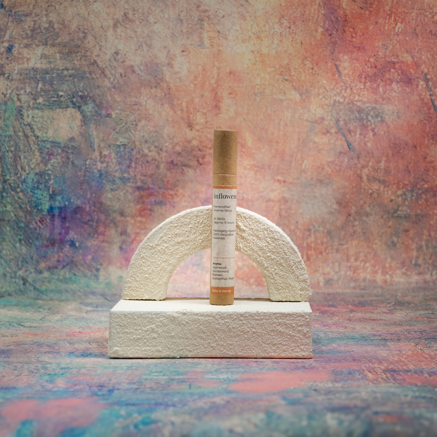 Petal & Nectar incense tube displayed with white textured decor in front of a Claude Monet–inspired canvas — a serene, romantic composition that highlights the gentle elegance of the scent.