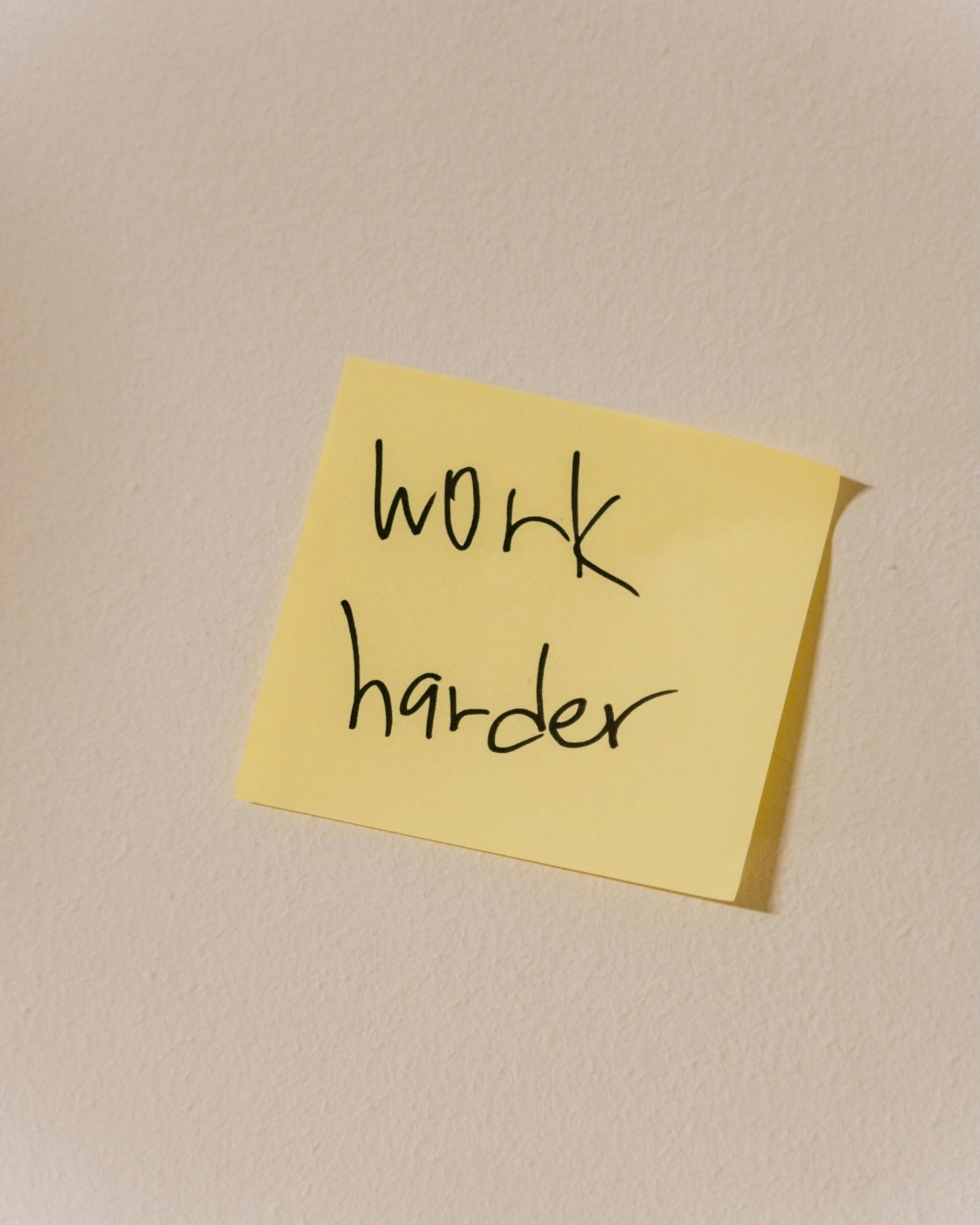Sticky note with ‘Work harder’ written on it, representing the pressure and hustle culture inflowence invites you to step away from.