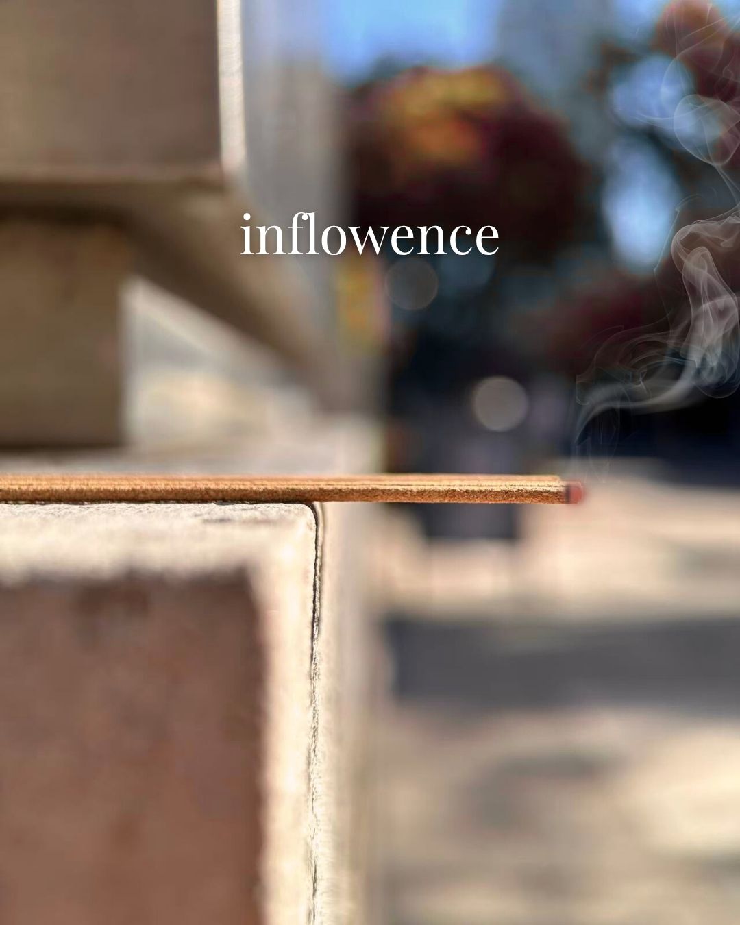 Natural Incense stick with smoke and 'inflowence' branding in a blurred outdoor setting