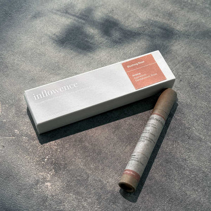 Inflowence Blushing Rose incense set with a white rectangular box and matching kraft paper tube on a sunlit stone surface—crafted with agarwood, sandalwood, and rose to encourage self love and emotional grounding through daily rituals.