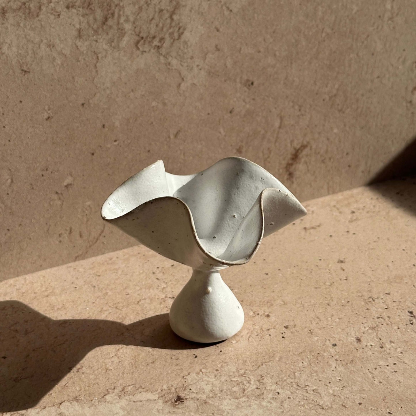 Handcrafted ceramic petal incense holder shown as a standalone sculptural object, featuring softly curved, folded edges and a matte speckled glaze.