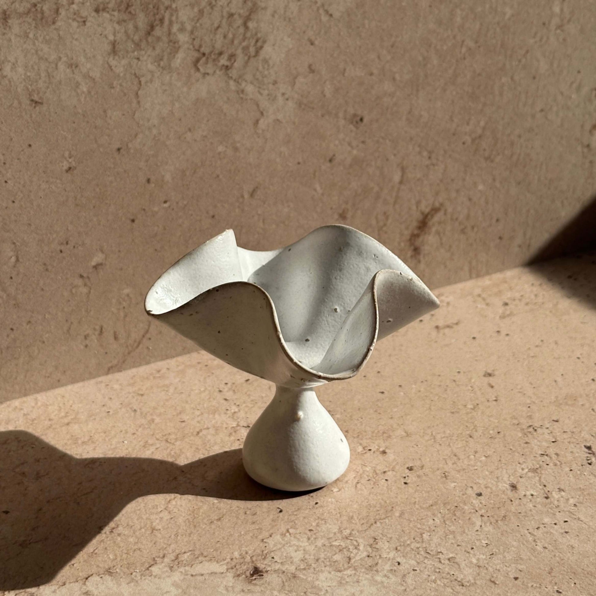 Handcrafted ceramic petal incense holder shown as a standalone sculptural object, featuring softly curved, folded edges and a matte speckled glaze.