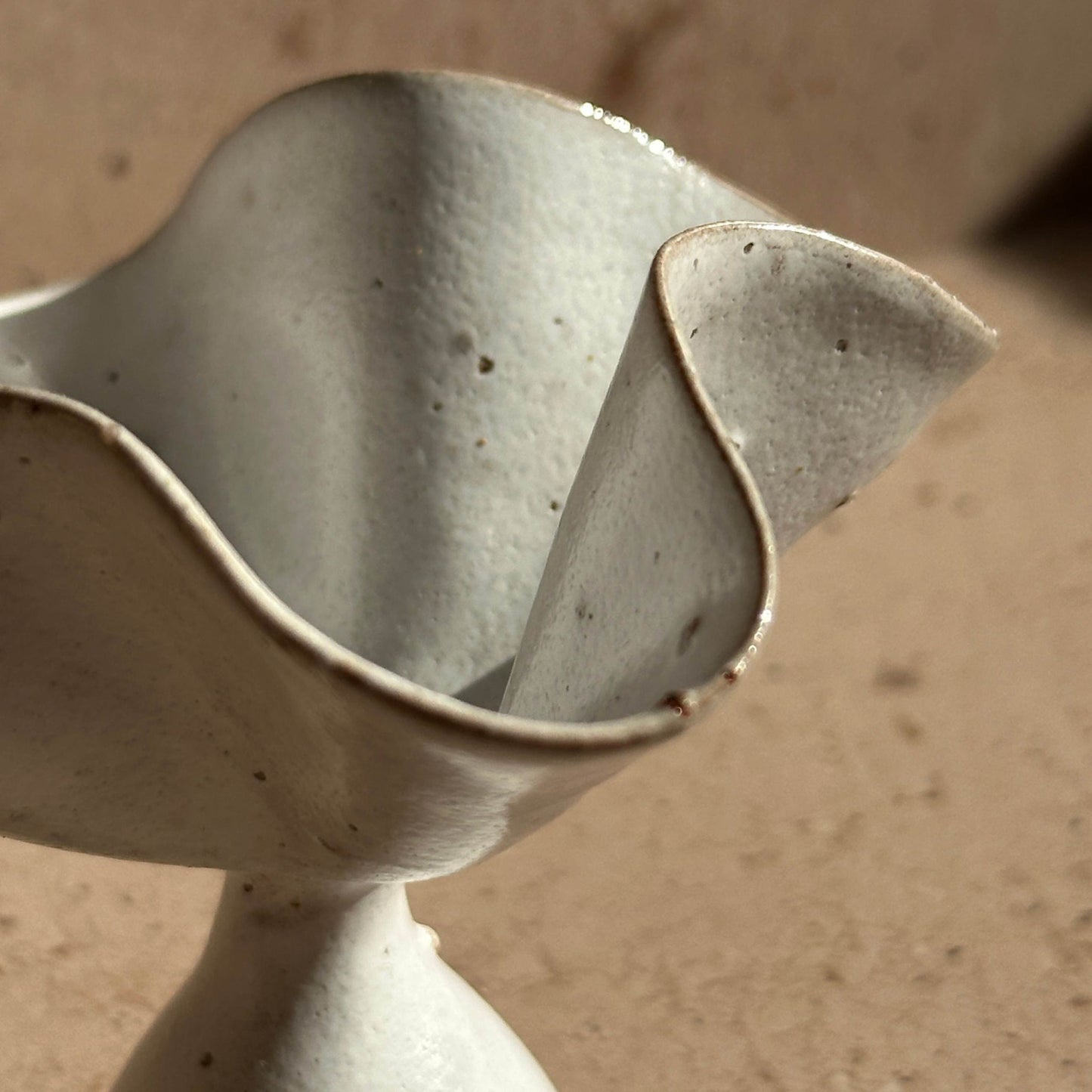 Close-up detail of a handcrafted ceramic petal incense holder, highlighting the softly curved rim, natural clay texture, and subtle variations from high-fired ceramic.