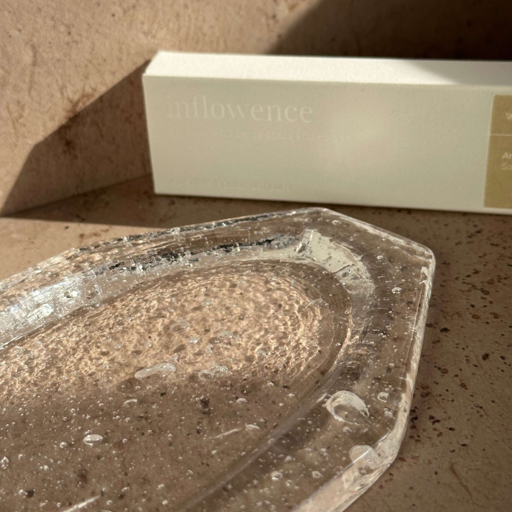 Detail view of a handcrafted glass ash catcher showing natural bubbles and textured glass surface