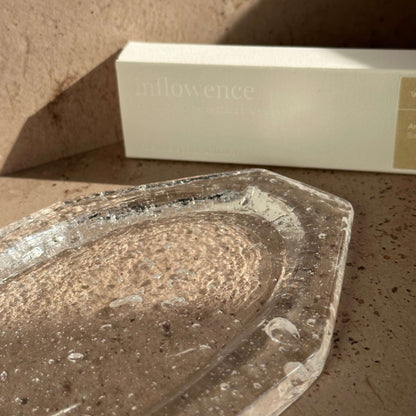 Detail view of a handcrafted glass ash catcher showing natural bubbles and textured glass surface