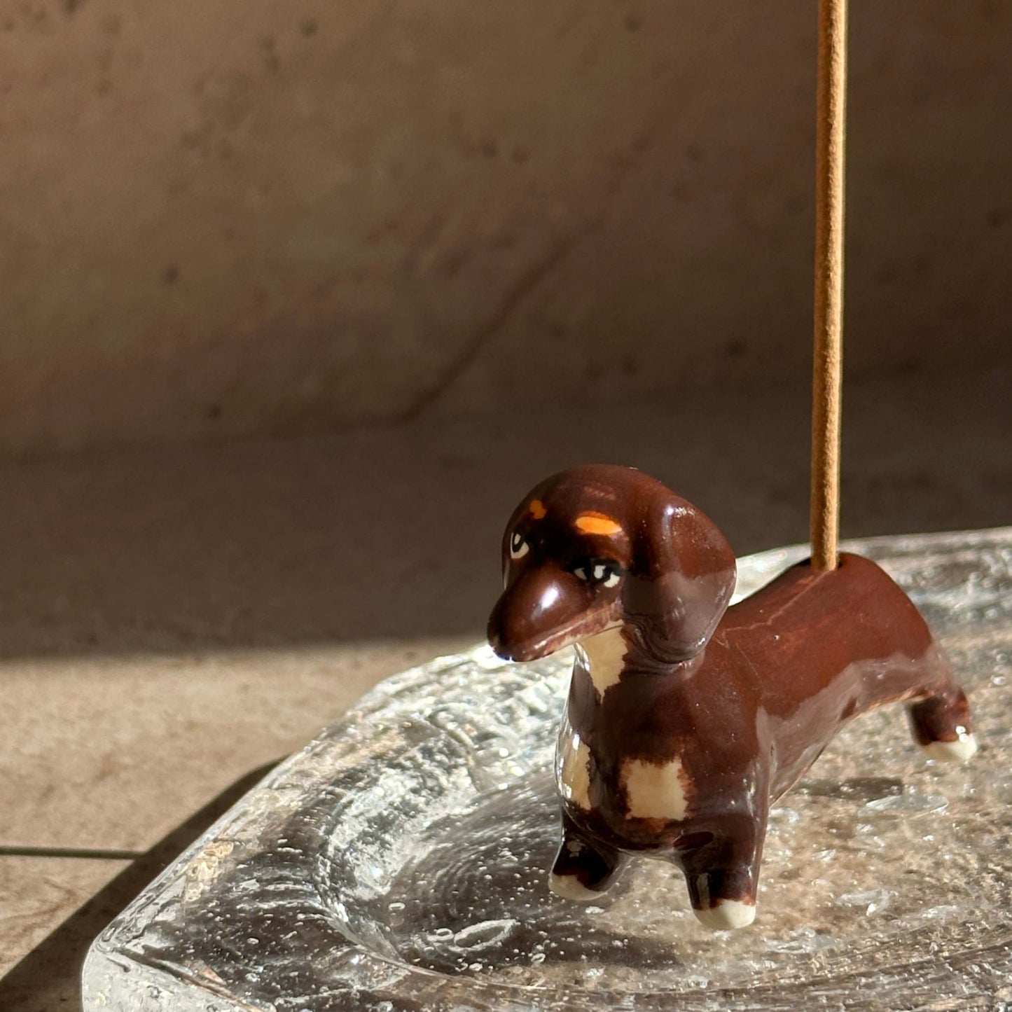 Handcrafted ceramic dachshund incense holder designed to hold incense sticks upright, blending playful form with everyday ritual.