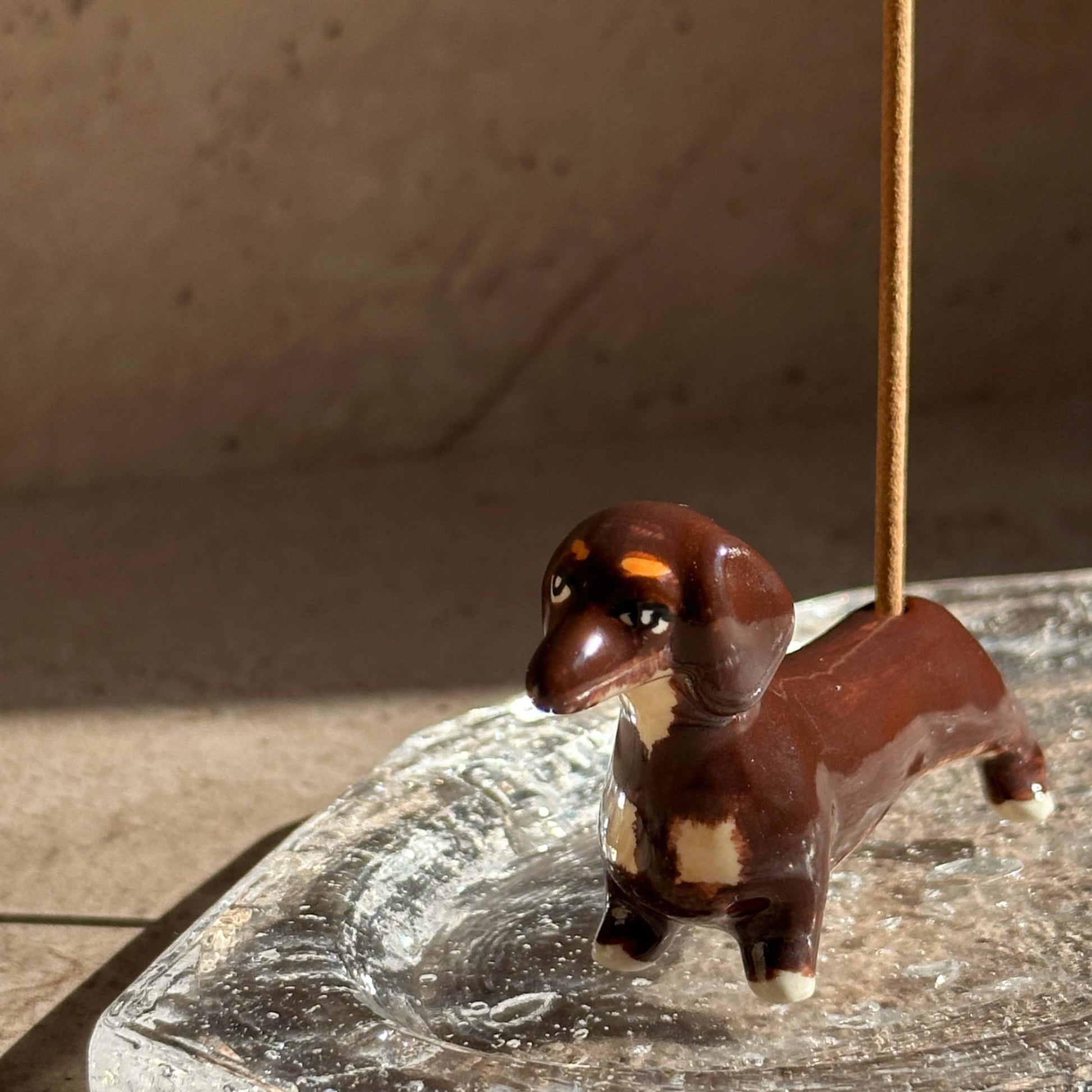 Handcrafted ceramic dachshund incense holder designed to hold incense sticks upright, blending playful form with everyday ritual.