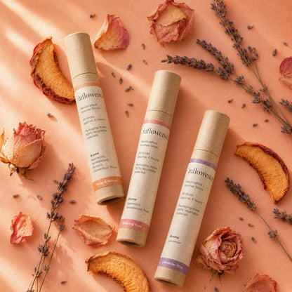 In Bloom Trio – Incense Set featuring Petal & Nectar flower incense, Blushing Rose rose incense, and Lavender Bliss lavender incense, arranged on a soft peach background with dried peach slices, lavender sprigs, dried roses, and scattered petals, designed to uplift the mood, soften stress, and bring light, refreshing floral rituals for busy minds.