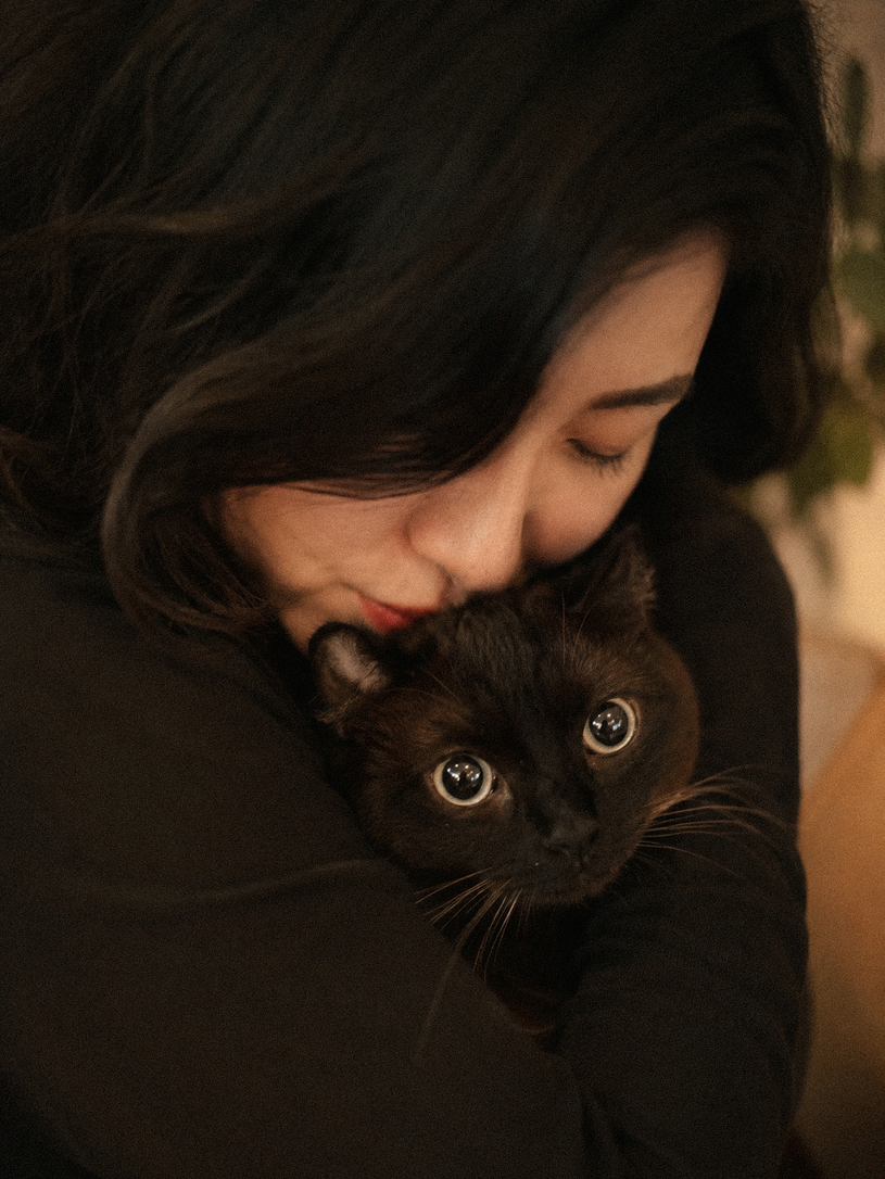 Inflowence founder holding a black cat in a warm, intimate portrait for the sensitive home collection, reflecting the care behind clean ingredient selection, asthma-conscious scent development, and incense made with care for homes with pets.