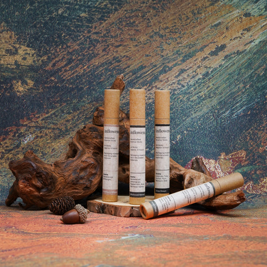 Earth-toned ritual set featuring incense sticks and packaging, placed in front of natural wood and set against a green, red, and yellow oil painting–inspired backdrop, evoking a calming and grounded atmosphere.