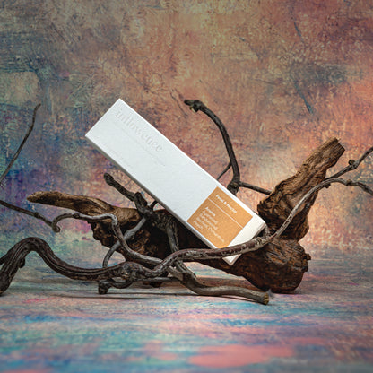Petal & Nectar incense box resting on natural wood with delicate branches, set against a Claude Monet–inspired canvas — a dreamy, floral scene evoking soft beauty and ritual calm.