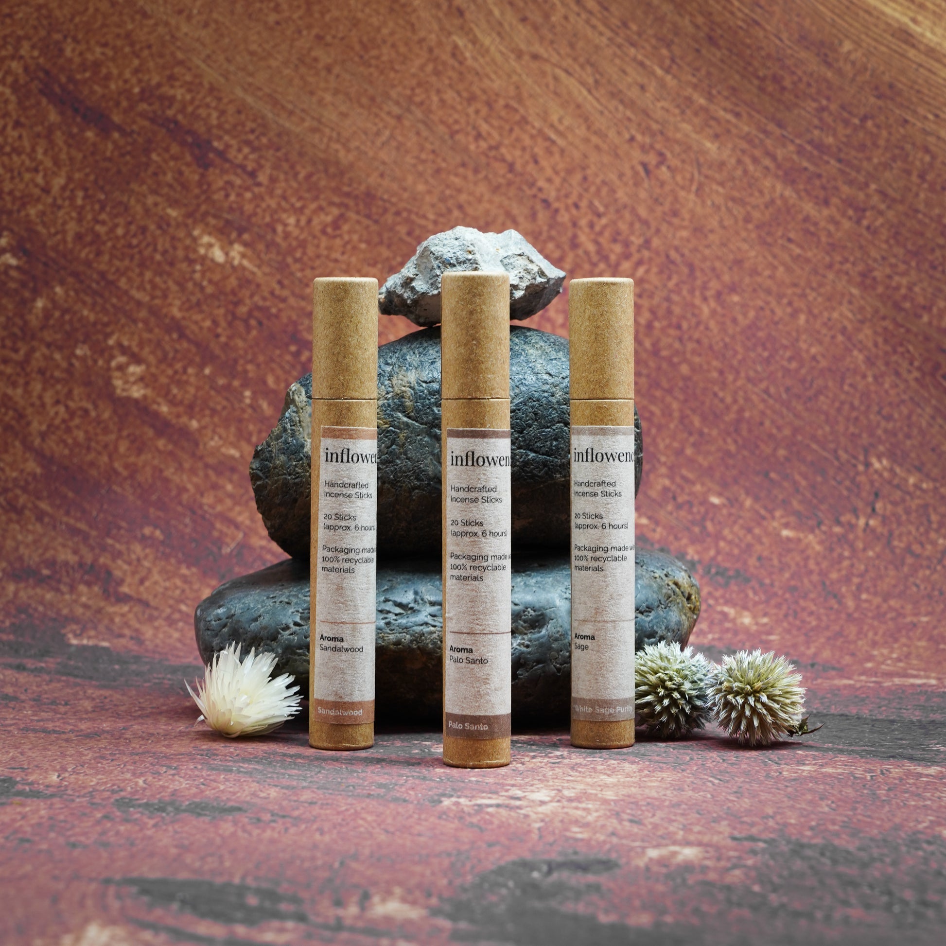 Sacred Aura Trio incense set displayed on rocks in front of a Grand Canyon-inspired oil painting backdrop, symbolizing spiritual cleansing and energy renewal with natural serenity and earthy calm.
