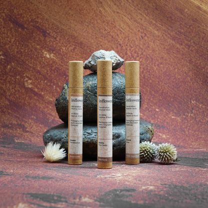 Sacred Aura Trio incense set displayed on rocks in front of a Grand Canyon-inspired oil painting backdrop, symbolizing spiritual cleansing and energy renewal with natural serenity and earthy calm.